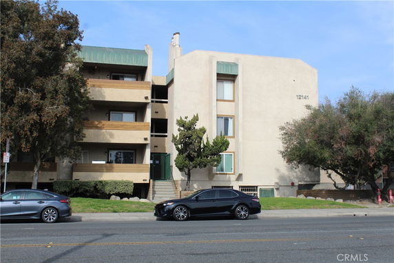 Front view of a multi-story apartment building with balconies.