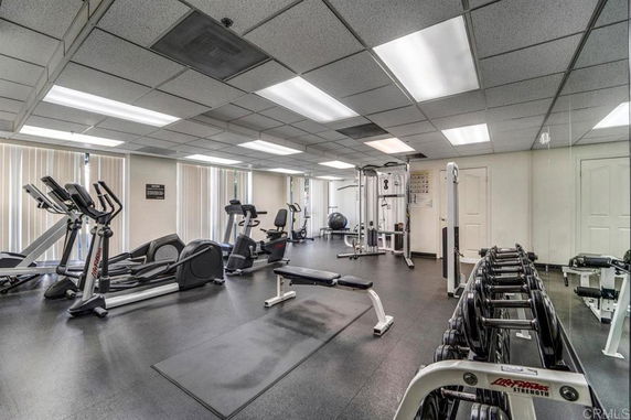 Interior view of a gym with exercise equipment and weights.