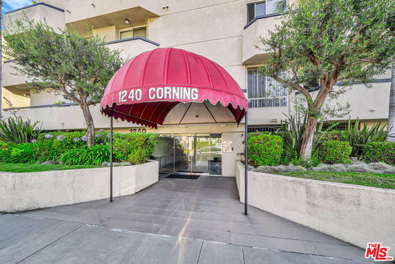 Front view of a multi-story building entrance with a red canopy.