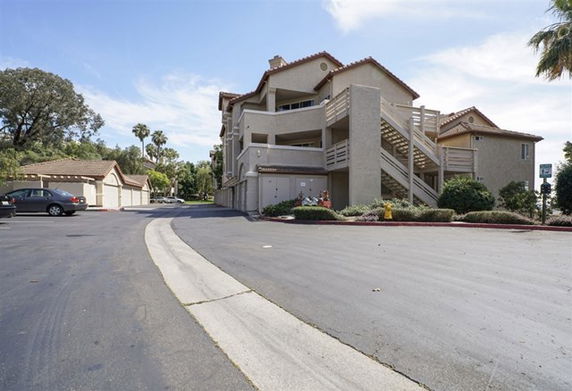 Front view of a multi-story apartment building with outdoor staircases.