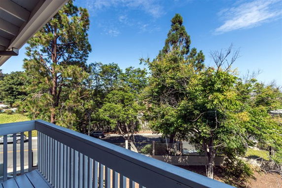 View from a balcony overlooking trees and a street