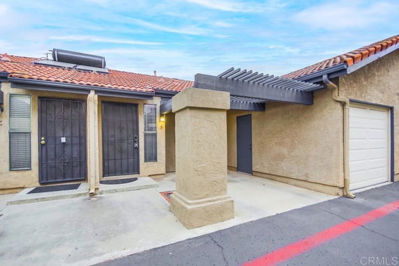 Front view of a house with a tiled roof, security doors, and a small garage.