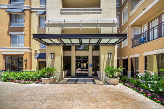 Front entrance of a multi-story building with glass canopy.