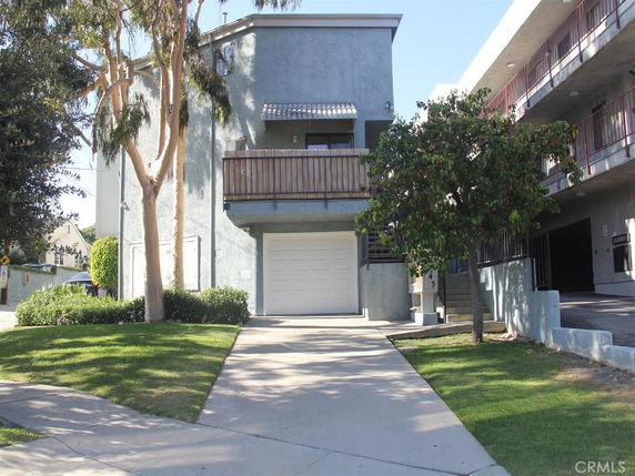 Front view of a multi-story building with a garage.