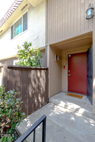 Front view of a two-story building with a red door entrance.