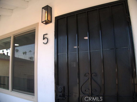 Front view of a house featuring a black metal door and a window.