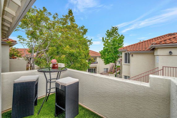 Balcony view overlooking residential buildings with tiled roofs.