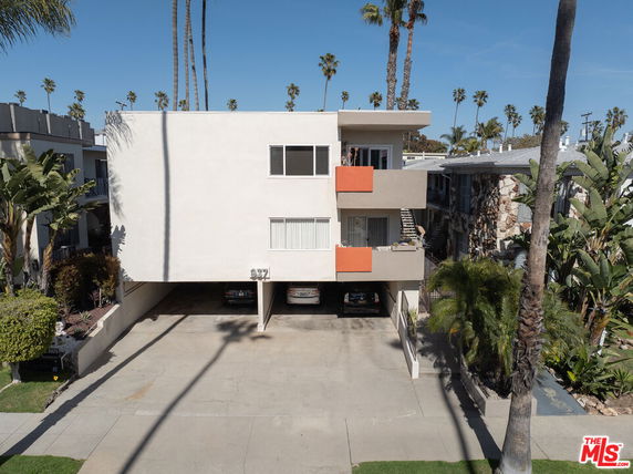 Front view of a two-story building with parking space underneath.