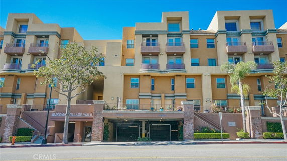 Front view of a multi-story apartment building with balconies.