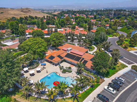 Aerial view of a residential area with houses and a central swimming pool.