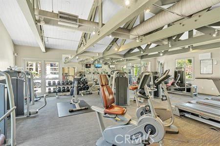 Interior view of a gym with various exercise equipment including treadmills, stationary bikes, and weight machines.
