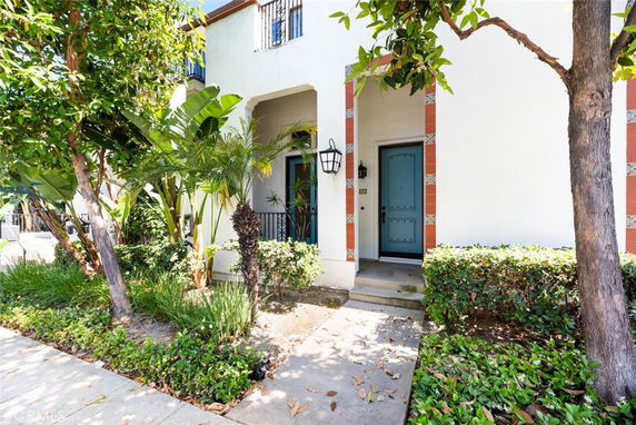 Front view of a house with a decorative entrance and plants by the doorway.
