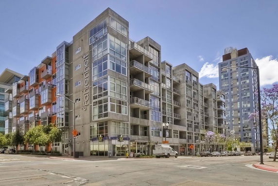 View of a multi-story modern apartment building from the street corner.