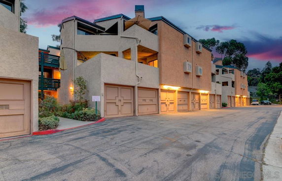 Front view of a multi-story residential building with garages.