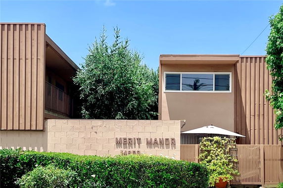 Front view of a two-story building labeled 'Merit Manor'.