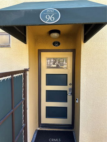 Front entrance view of a building with a door and an awning above.