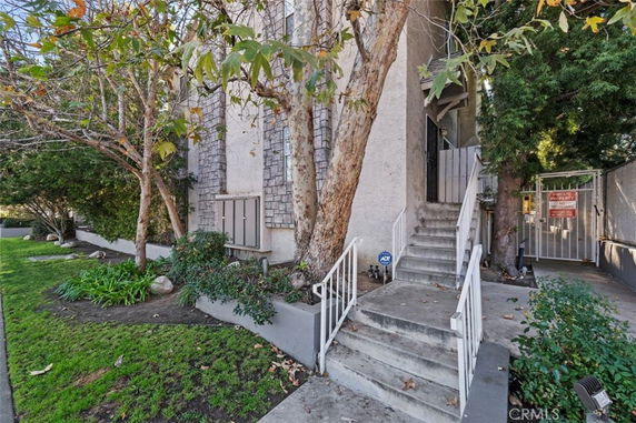 Front view of a multi-story building with stairs leading to the entrance.