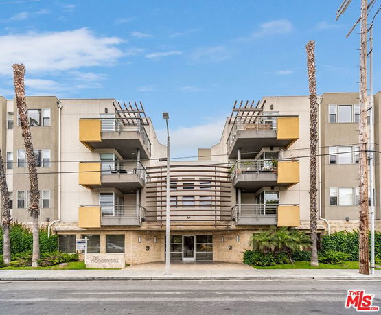 Front view of a modern multi-story apartment building with balconies.