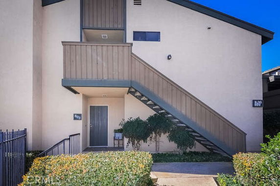 Front view of a multi-story building with external staircase.