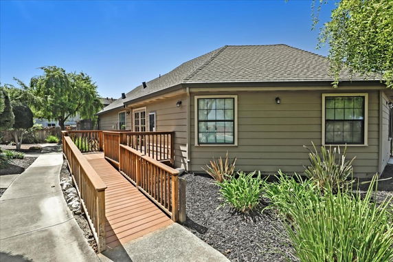 Side view of a single-story house with a wooden ramp.