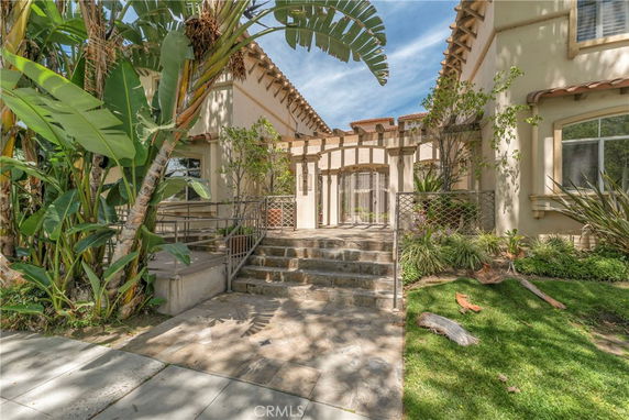 Front view of a two-story house with a decorative facade and landscaped entrance.