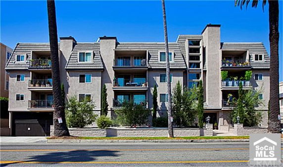 Front view of a multi-story apartment building with balconies.