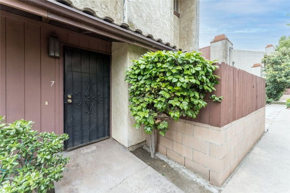 Front entrance of a house with a black door and a small fenced courtyard.