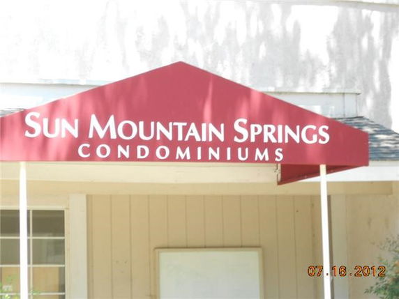 Front view of entrance to Sun Mountain Springs Condominiums with a red awning.