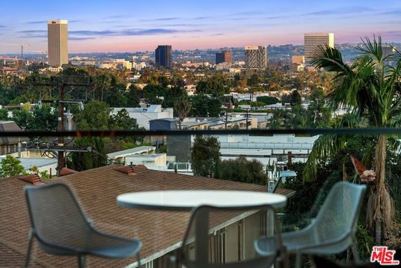 City skyline view from a balcony with patio furniture.