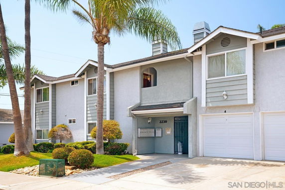 Front view of a two-story townhouse with individual garages.