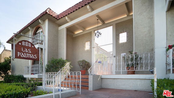 Front view of a house with a balcony and wrought-iron railings.