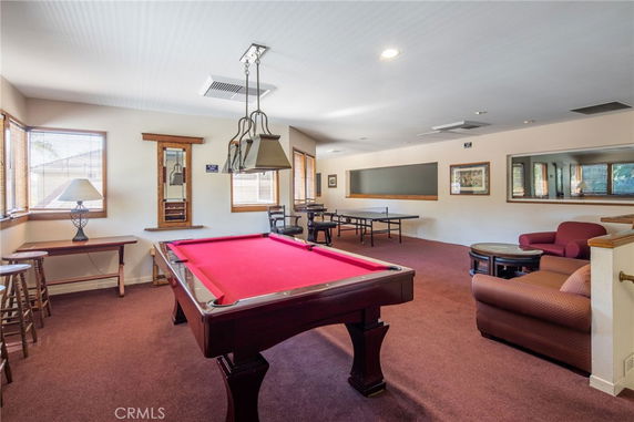 Indoor recreational area with a pool table and seating.
