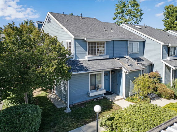 Front view of a two-story townhouse with a blue exterior and sloped roof.