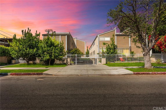 Front view of a multi-story apartment building with a gated entrance.