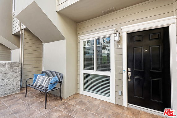 Front view of a residential entryway with a black door and a window.