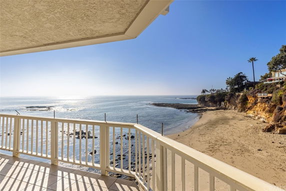 Coastal view from a balcony overlooking the ocean and beach.