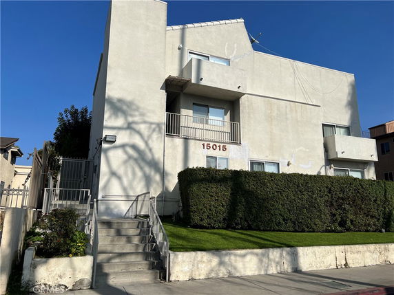 Front view of a multi-story building with a staircase and balconies.