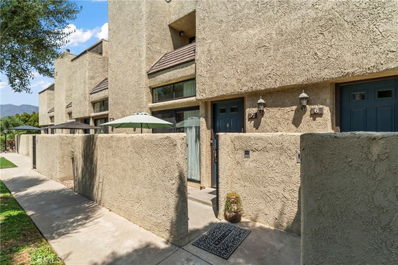 Front view of a row of modern townhouses with textured walls and blue doors.