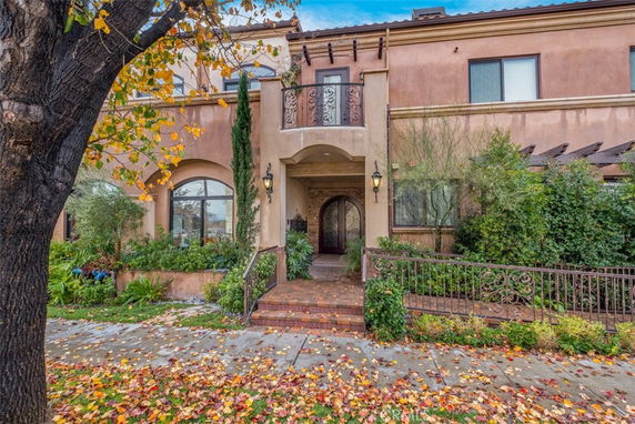 Front view of a two-story house with decorative railing and archway entrance.