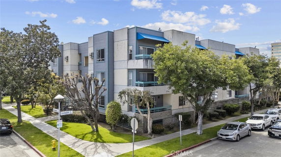 Corner view of a multi-story residential building with balconies and a contemporary design.