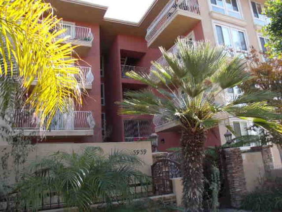 Front view of a multi-story apartment building with balconies and a prominent entryway.