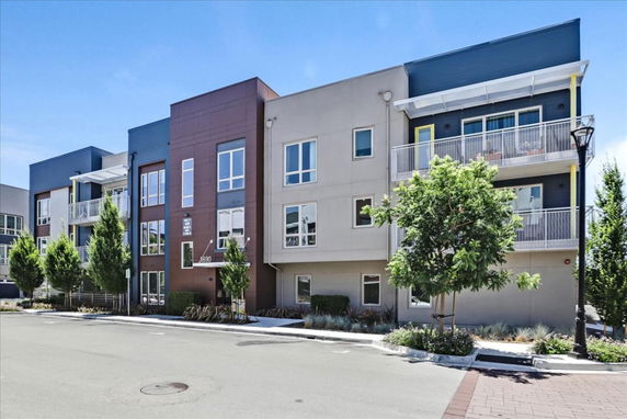 Front view of a modern multi-story apartment building with balconies.