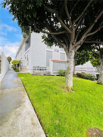 Front view of a two-story building with white exterior and a small lawn area.