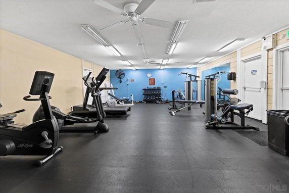 Indoor gym area with various exercise equipment and machines.