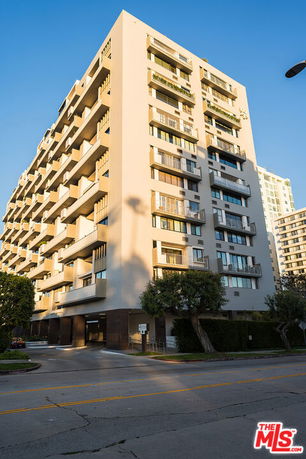 Front view of a multi-story apartment building with multiple balconies.