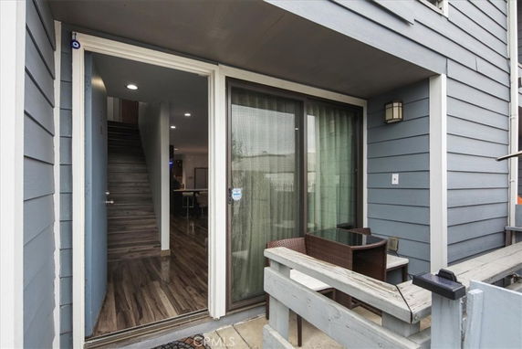 Front view of a house entrance with a sliding glass door and small patio area.