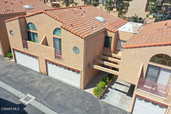 Elevated view of a stucco house with tiled roof and two-car garages.