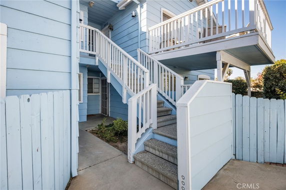 Front view of a house with blue exterior and stairs leading to the second level.
