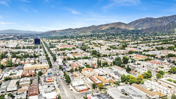 Wide-angle aerial view of a cityscape with mountains in the background.