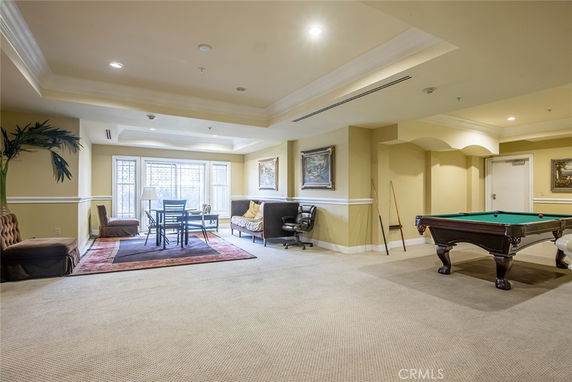 Interior view of a clubhouse room with a pool table and seating area.